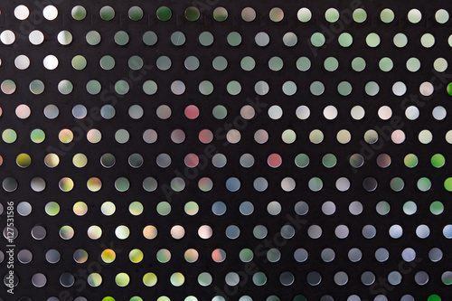 Black metal surface with round holes. Background. Pattern.