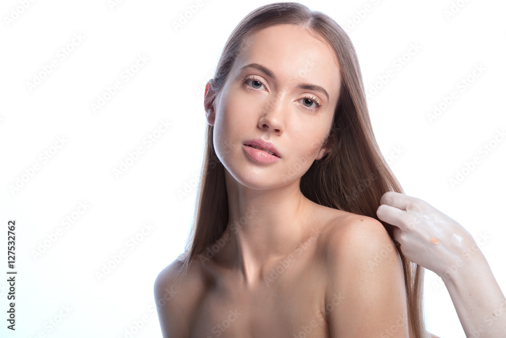 Face in beauty style. Makeup artist applying cosmetics and combing hair on a model Face in beauty style. Makeup artist applying cosmetics and combing hair on a model
