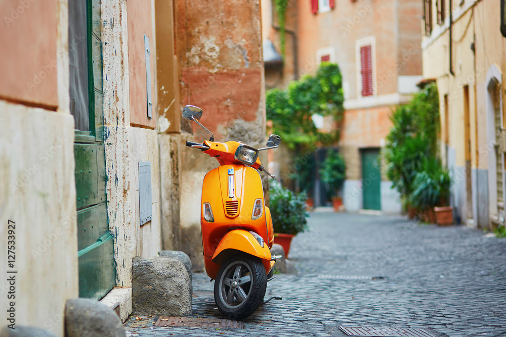 Old fashioned orange motorbike on a street of Trastevere district, Rome