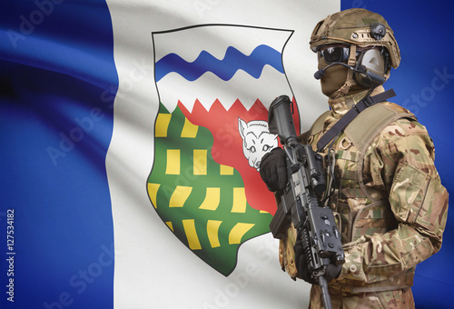 Soldier in helmet holding machine gun with Canadian province flag on background series - Northwest Territories