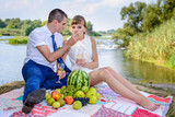 Newlywed young couple relaxing on a river bank