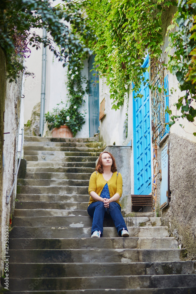 Tourist sitting on stairs in Positano, Italy