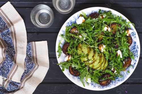 Arugula salad with goat cheese and avocado with plums  