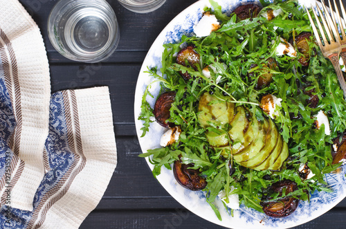 Arugula salad with goat cheese and avocado with plums  