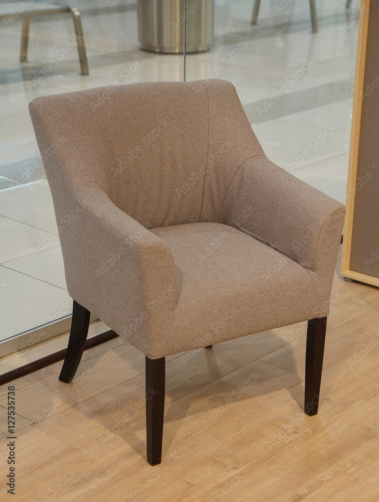 Stylish beige chair stands at the window. Furniture Stylish beige chair stands at the window. Furniture