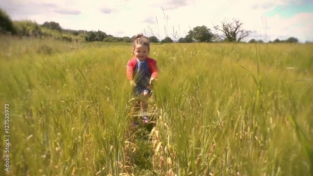 Young girl running through a wheat field running towards the camera. Filmed in slow motion Young girl running through a wheat field running towards the camera. Filmed in slow motion