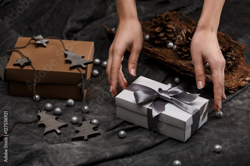 Girl's hands put gift box on table. Christmas decoration background. photo