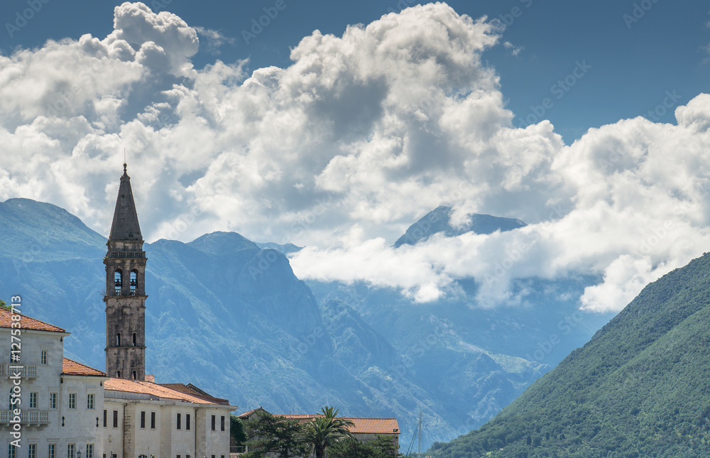 Mountains and dramatic cloudscapes in Montenegro are the backdrop for the quaint historic buildings of the medieval village of Perast.