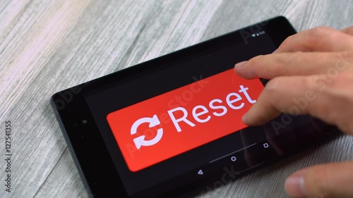 Reset button enlarged and pressed on tablet computers' touchscreen display