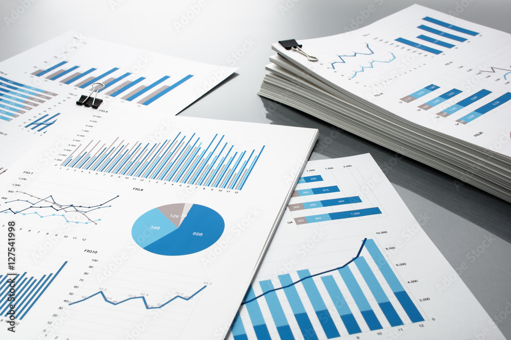 Prepareing report. Blue graphs and charts.
Business reports and pile of documents on gray reflection background.
 - obrazy, fototapety, plakaty 