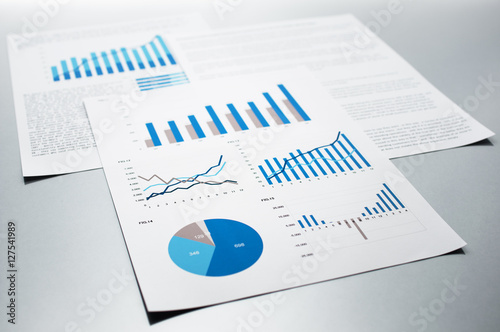 Business reports. Graphs and charts. Documents on gray reflection background. 
