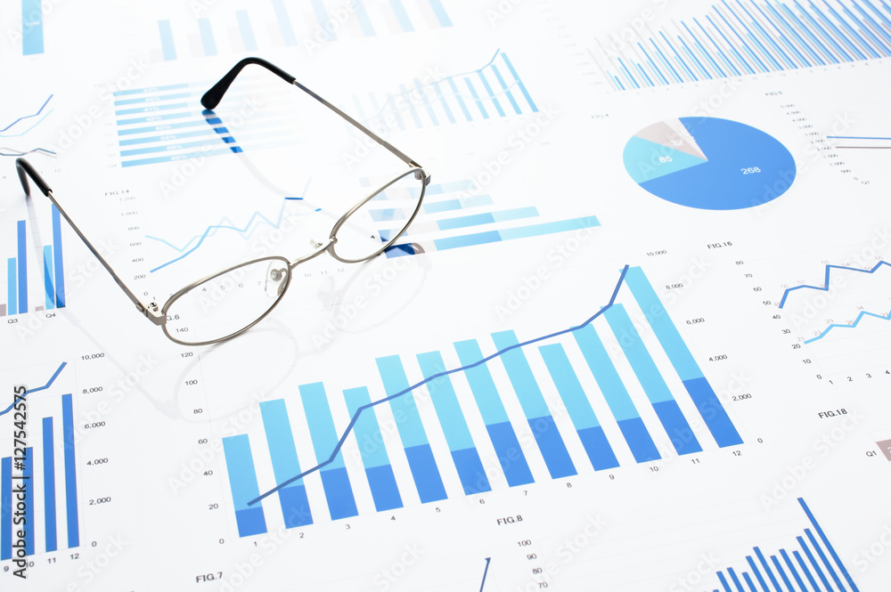 Many charts and glasses. Reviewing data. Financial reports and glasses. Reflection background.
Many charts and glasses. Reviewing data. Financial reports and glasses. Reflection background.