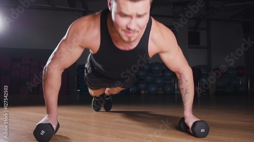 Young muscular athlete doing pushups photo