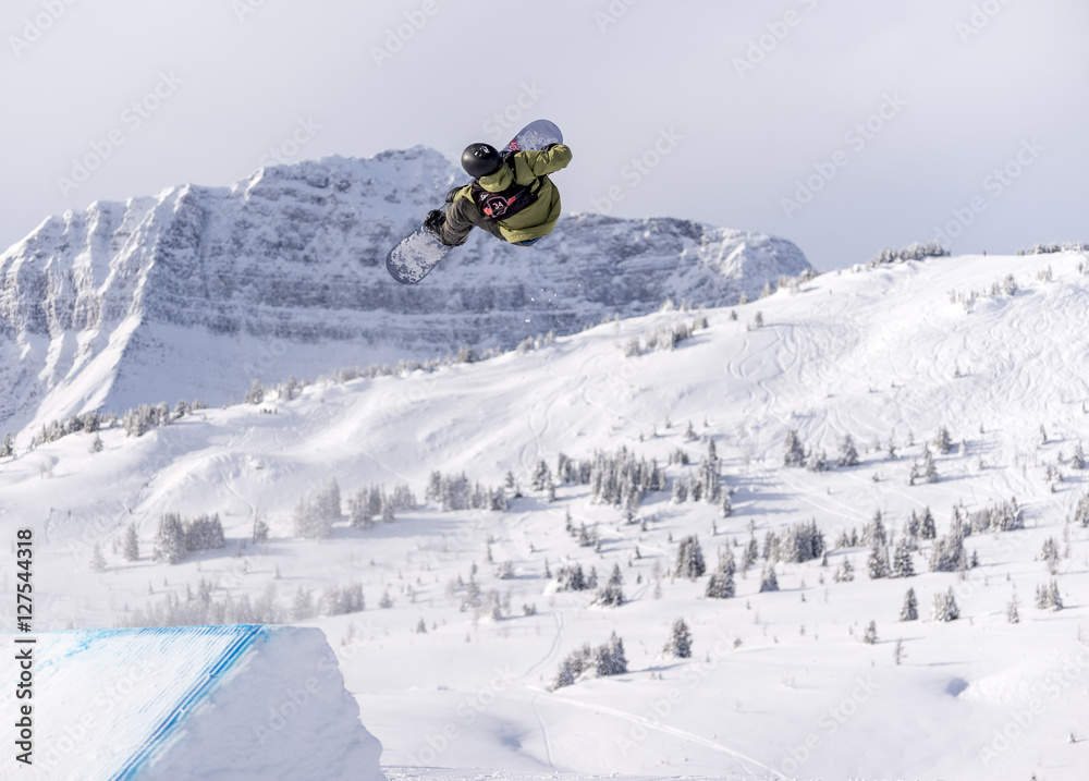 Snowboarder spinning doing a grab in the air