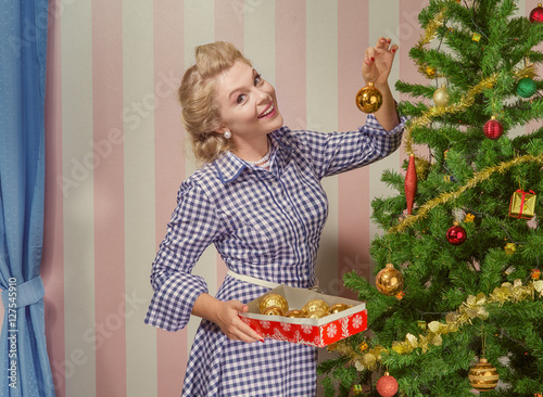Bild auf Leinwand portrait of nice young woman hanging around christmas tree on x-mas  eve