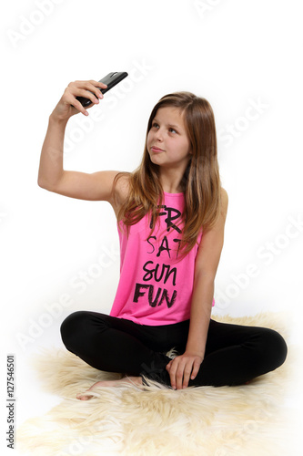 Śliczna dziewczyna, nastolatka robi sobie selfie na białym tle.