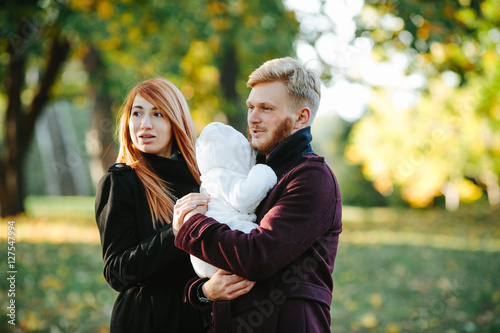 young family and newborn son in autumn park