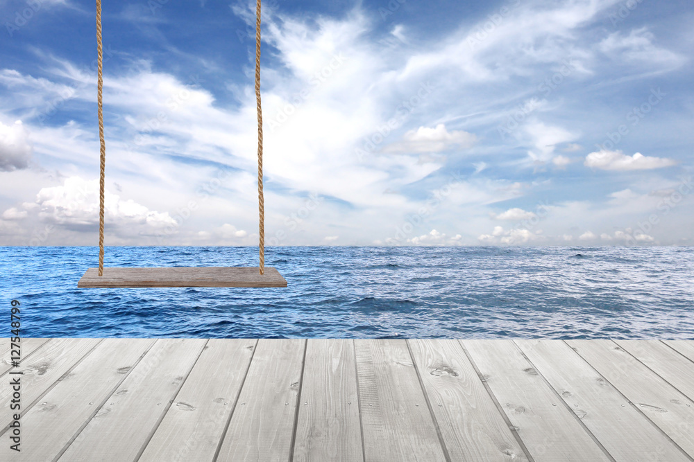 wooden swing and wood floor on sea wave in blue sky background.