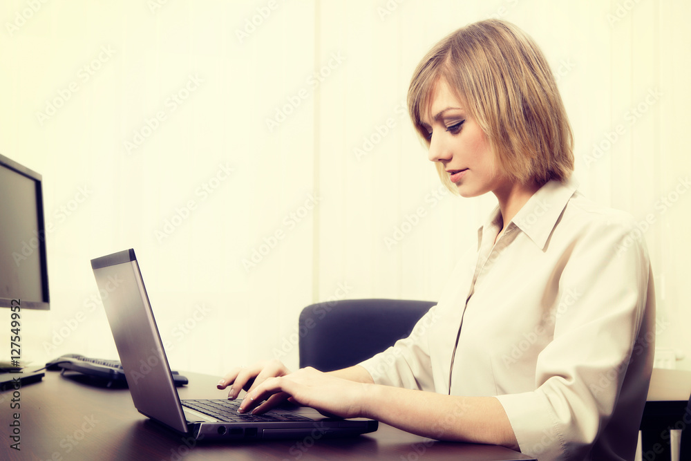 Blonde businesswoman working on computer at the office Blonde businesswoman working on computer at the office