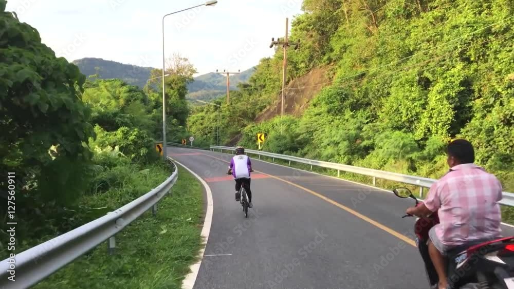 Healthy thai woman cycling down road bicycle outdoors fitness steadicam shot