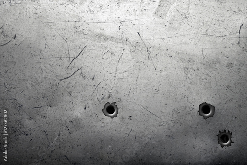 Scratched metal background with bullet holes photo