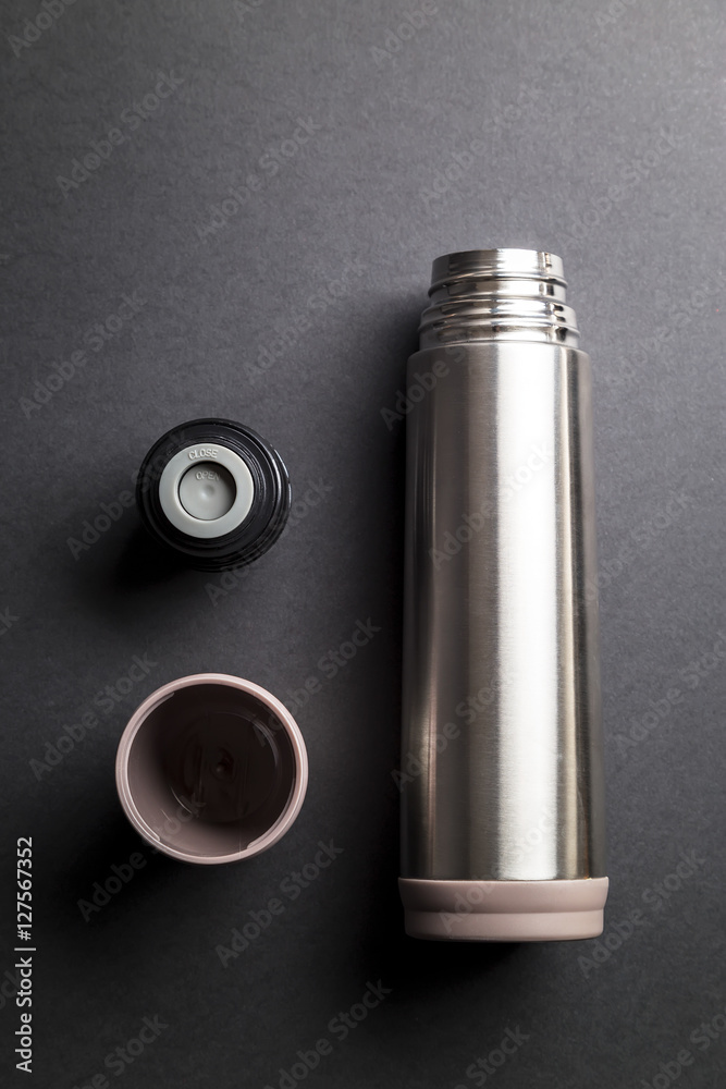 Metallic thermos over black background presentation Metallic thermos over black background presentation