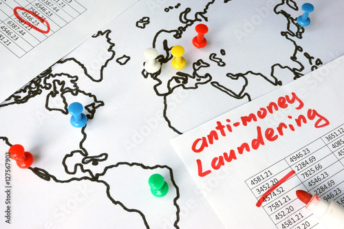 Anti-money laundering (AML) concept. Data and thumb tacks in a map.