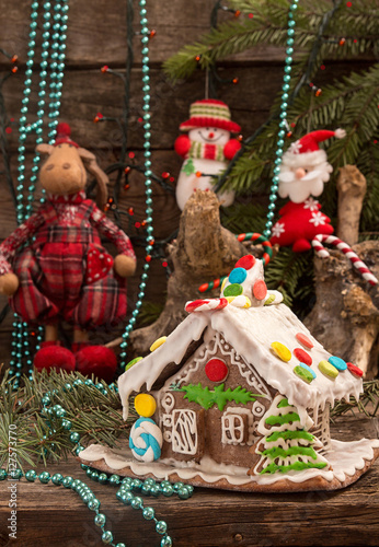 Christmas gingerbread house and holiday decorations on old woode