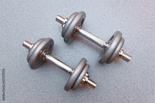 two sports dumbbells on a grey background