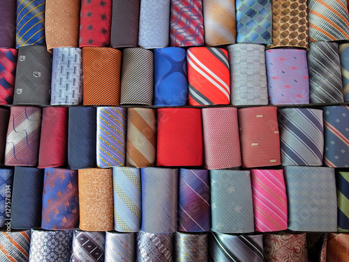 Close up of rolled up neckties. Shot of a multi-colored collection of rolled-up ties. Colorful ties rolled up and placed in rows. 