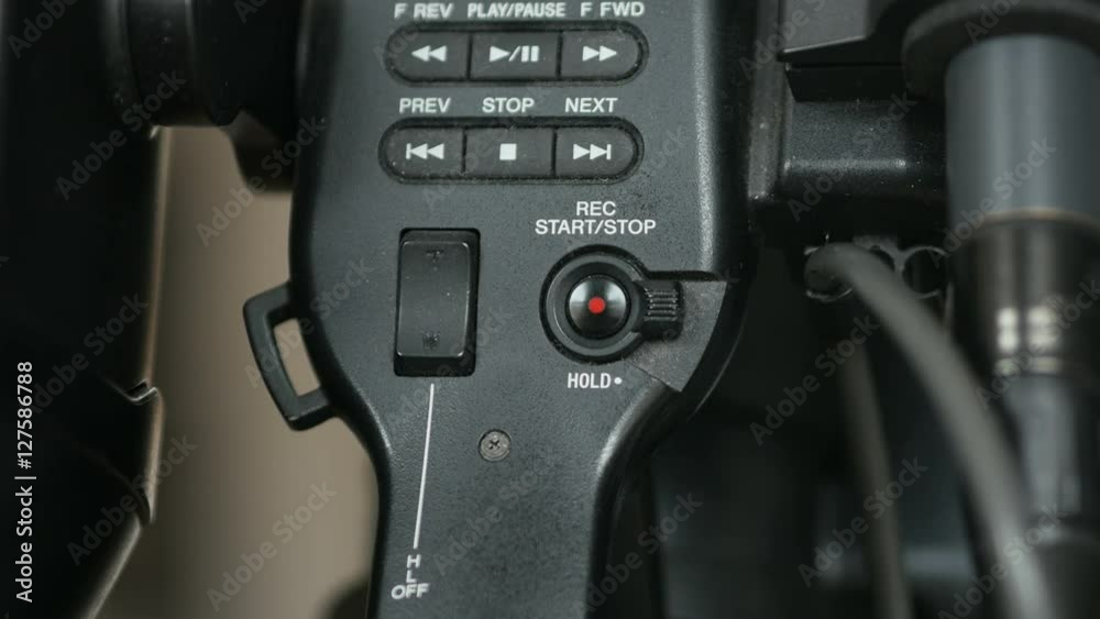 Pressing the top handle record button on an ENG video camera. Pressing the top handle record button on an ENG video camera.