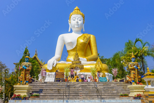Thai pilgrims worship the big sitting Buddha statue at Wat Phra That Doi Kham. It is a landmark in Tambon Mae Hia, Amphoe Mueang. © joeyphoto
