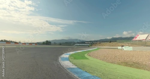 Drone flying along the road or POV race car speeding along the curve racetrack. photo