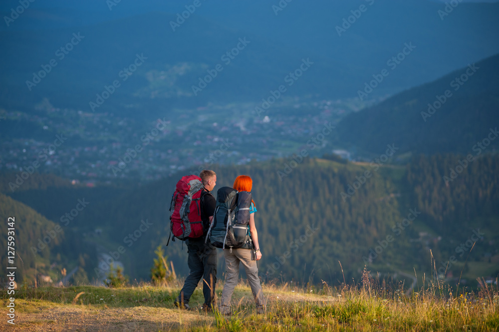 Turist family with backpacks holding hands and hiking with beautiful mountain landscape on background Turist family with backpacks holding hands and hiking with beautiful mountain landscape on background