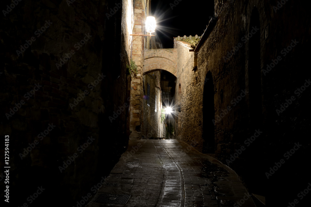 Narrow passage at night in San Gimignano, Italy