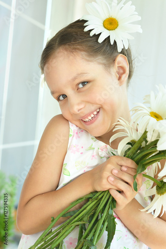 Little girl with dasies flowers photo