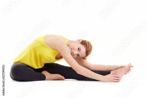 Fit woman stretching her leg to warm up - isolated over white background
