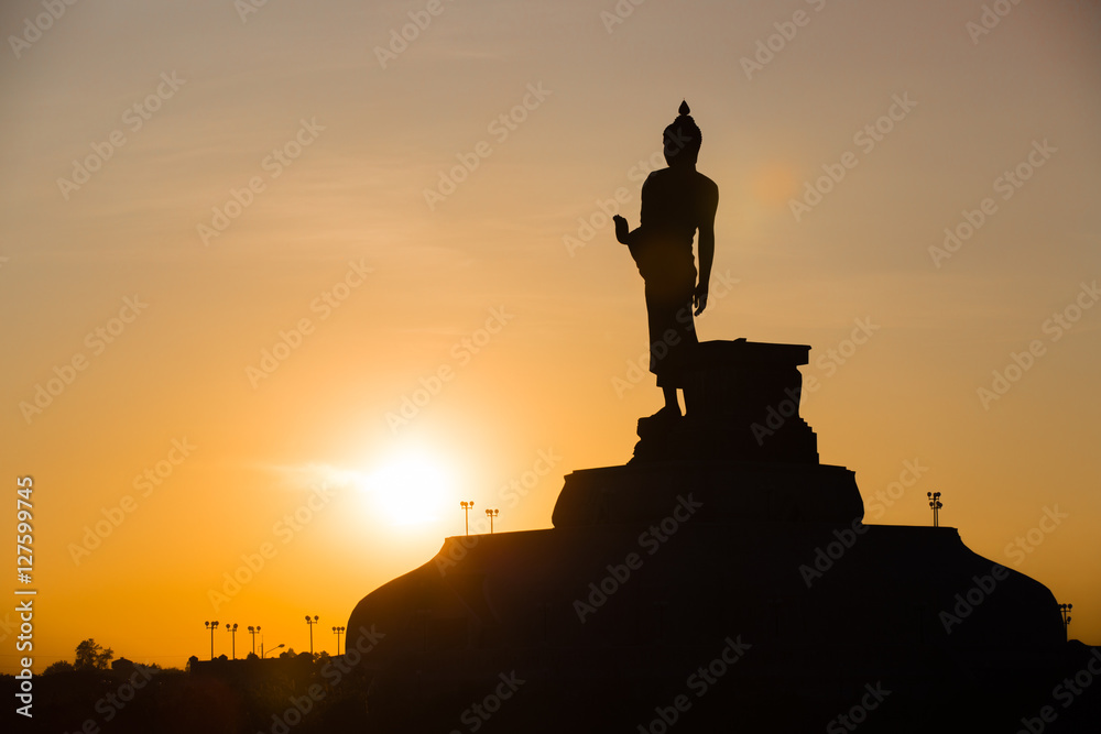 Fototapeta premium Silhouette Of The Posture Of Walking Buddhist Statue In Twilight
