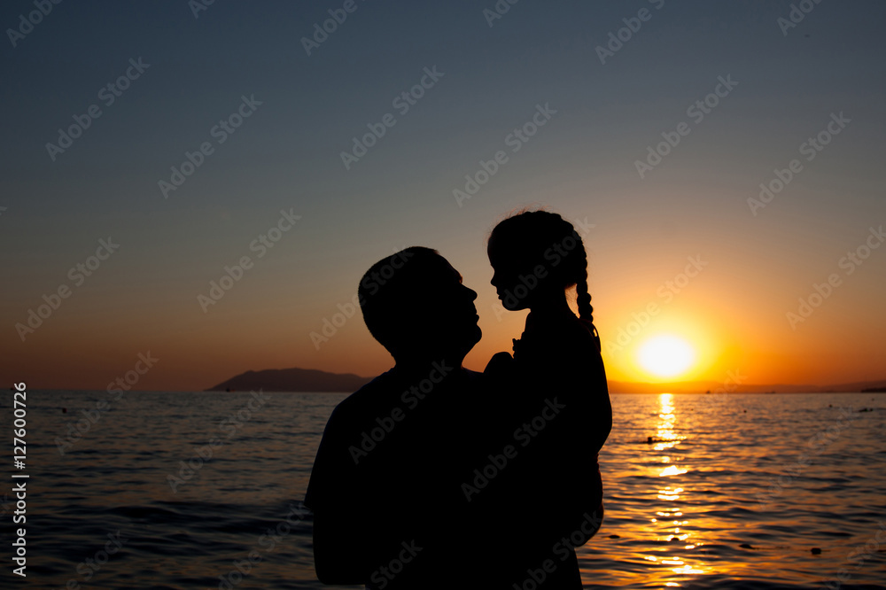 Silhouette of woman and little girl,enjoying and relaxing, on th