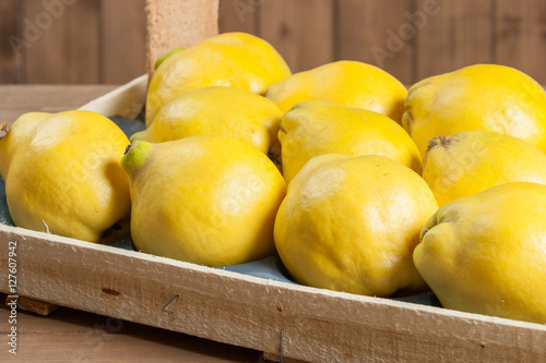Ripe Quince Fruits In Wooden Box.