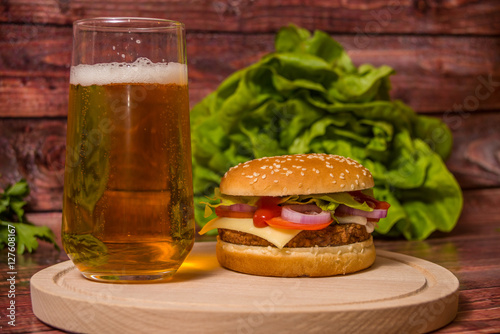 Hamburger and beer on wooden board