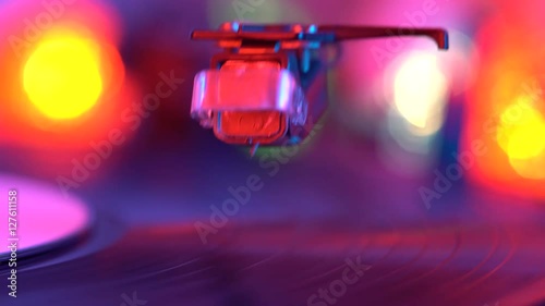 Vinyl disc turning on retro record player. The needle drops on the disc, macro