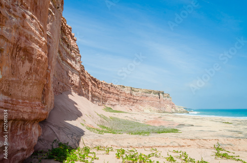 Towering red sandstone cliffs at Angola's coast line photo