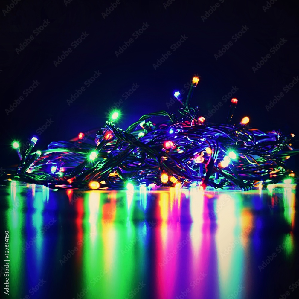 Christmas blurred lights on black background with copy space. Abstract colorful reflections of bulbs on a Christmas tree. Christmas blurred lights on black background with copy space. Abstract colorful reflections of bulbs on a Christmas tree.