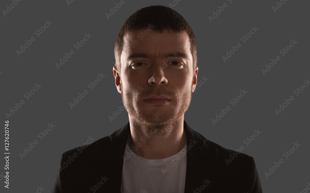 Brave and strong man portrait with backlight. Serious face of european person. Boy in white shirt and black coat. Buseness look to the camera. Brave and strong man portrait with backlight. Serious face of european person. Boy in white shirt and black coat. Buseness look to the camera.