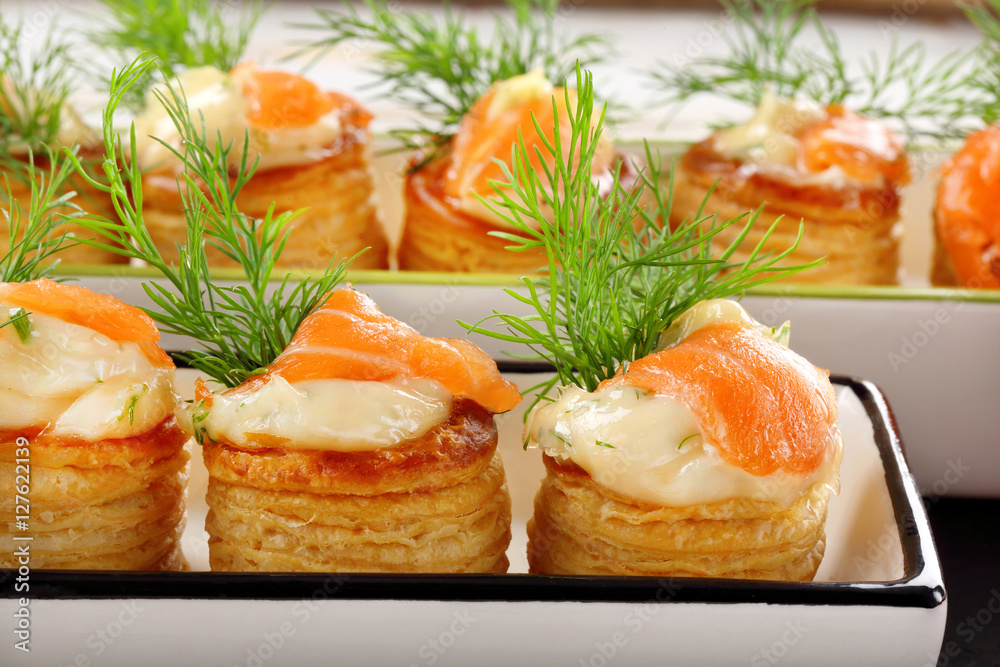 Salmon appetizer with dill dip in puff pastry on stone tray Salmon appetizer with dill dip in puff pastry on stone tray