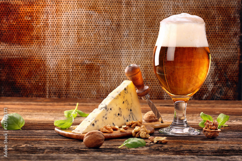 Blue cheese appetizer and beer on brown vintage background