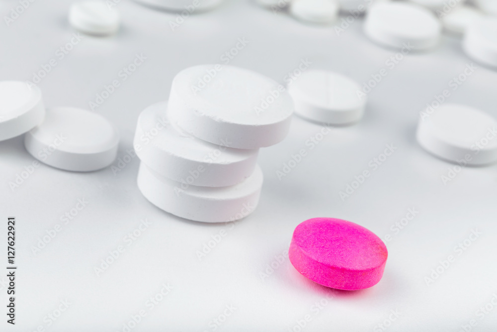 Bunch of white tablets. Scattered pills. Single pink pill Bunch of white tablets. Scattered pills. Single pink pill