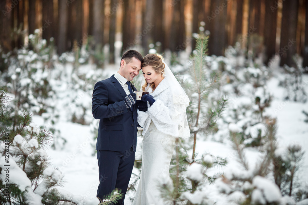 Winter, bride and groom holding cups of coffee in cold winter wedding day Winter, bride and groom holding cups of coffee in cold winter wedding day