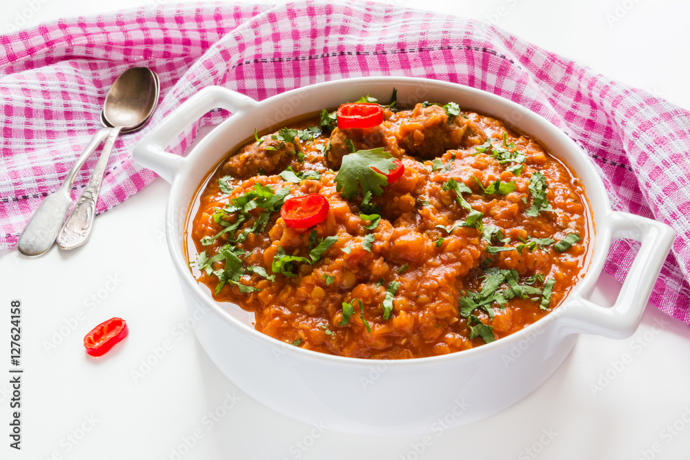 Spicy lentil and meatball soup with parsley. Casserole on white table. Spicy lentil and meatball soup with parsley. Casserole on white table.
